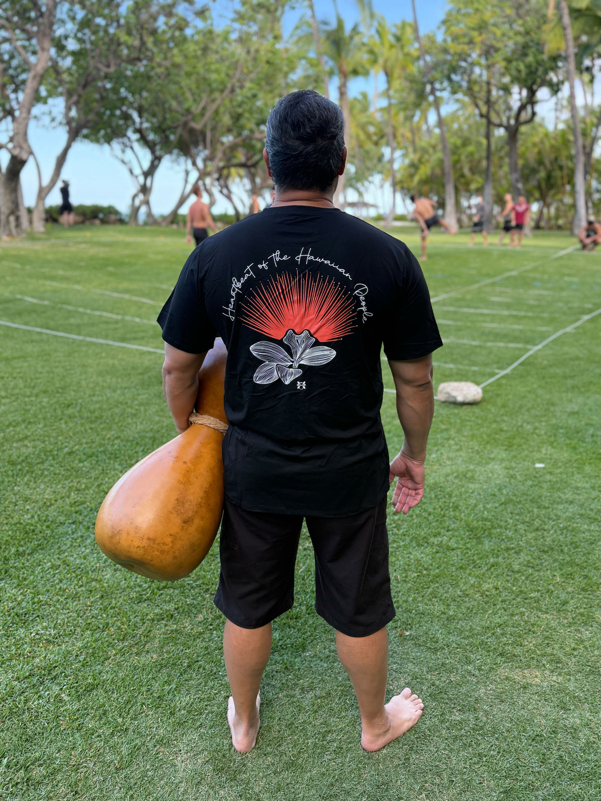 Hula is Life Lehua ʻUla T-shirt featuring vibrant floral design, casual fit, and Hawaiian-inspired artwork.